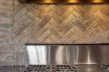 This stunning kitchen boasts a modern stainless steel range and a beautiful brick backsplash, creating a warm and inviting atmosphere.