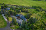 This stunning property boasts a luxurious home surrounded by lush greenery and mature trees.