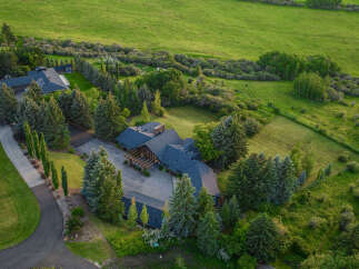 This stunning property boasts a luxurious home surrounded by lush greenery and mature trees.
