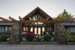 This stunning property boasts a unique architectural design, featuring a striking wooden pergola and a stone facade.