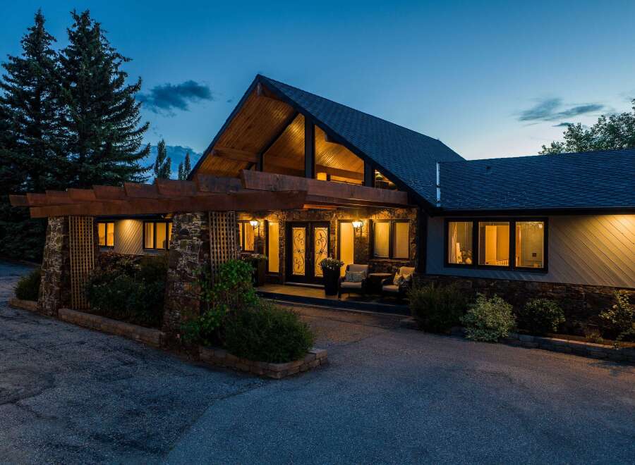 This stunning property boasts a unique architectural design with a striking A-frame roof and inviting entrance.