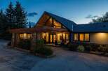 This stunning property boasts a unique architectural design with a striking A-frame roof and inviting entrance.