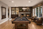 Experience ultimate relaxation and entertainment in this stunning basement game room, featuring a professional billiard table and a cozy stone fireplace.