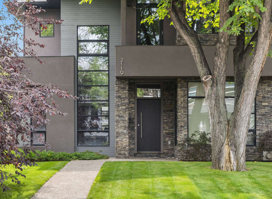 This stunning modern home boasts a striking facade with a combination of stone and sleek architectural details.