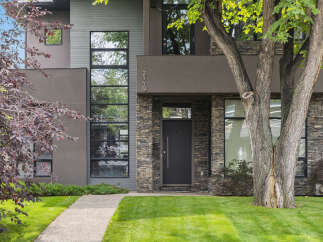 This stunning modern home boasts a striking facade with a combination of stone and sleek architectural details.
