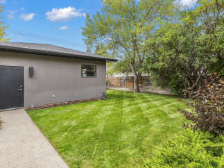 Discover the charm of this property, featuring a well-maintained backyard with lush green grass.