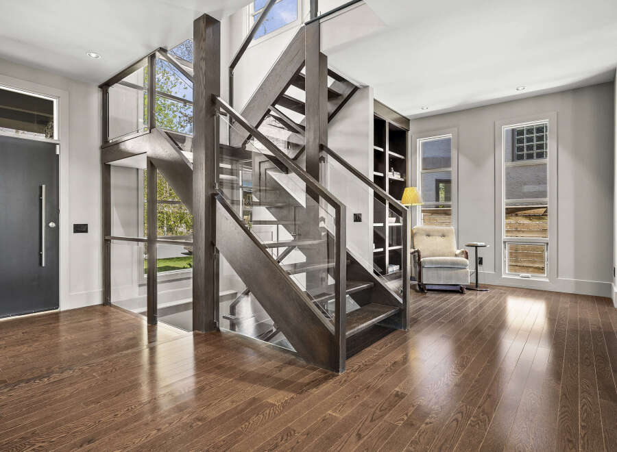 Step into luxury with this stunning home featuring a modern staircase with glass railings, creating an open and airy feel.