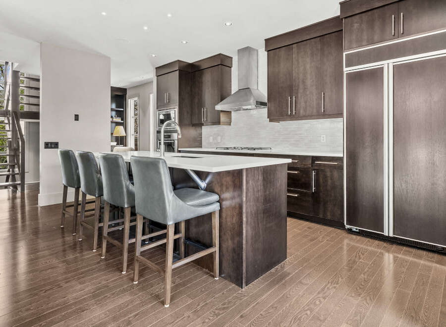 This stunning kitchen boasts modern design with dark wood cabinetry and a sleek island.