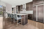 This stunning kitchen boasts modern design with dark wood cabinetry and a sleek island.