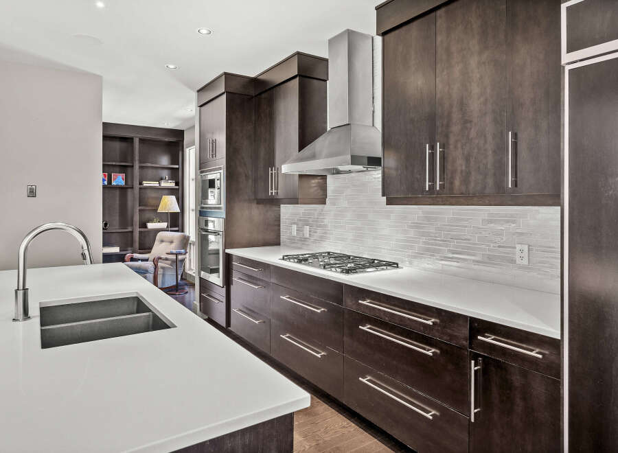 This stunning kitchen boasts modern design with dark wood cabinetry and sleek stainless steel appliances.