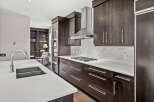 This stunning kitchen boasts modern design with dark wood cabinetry and sleek stainless steel appliances.