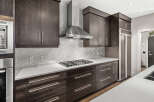 This modern kitchen boasts sleek dark wood cabinetry, offering ample storage and a sophisticated aesthetic.