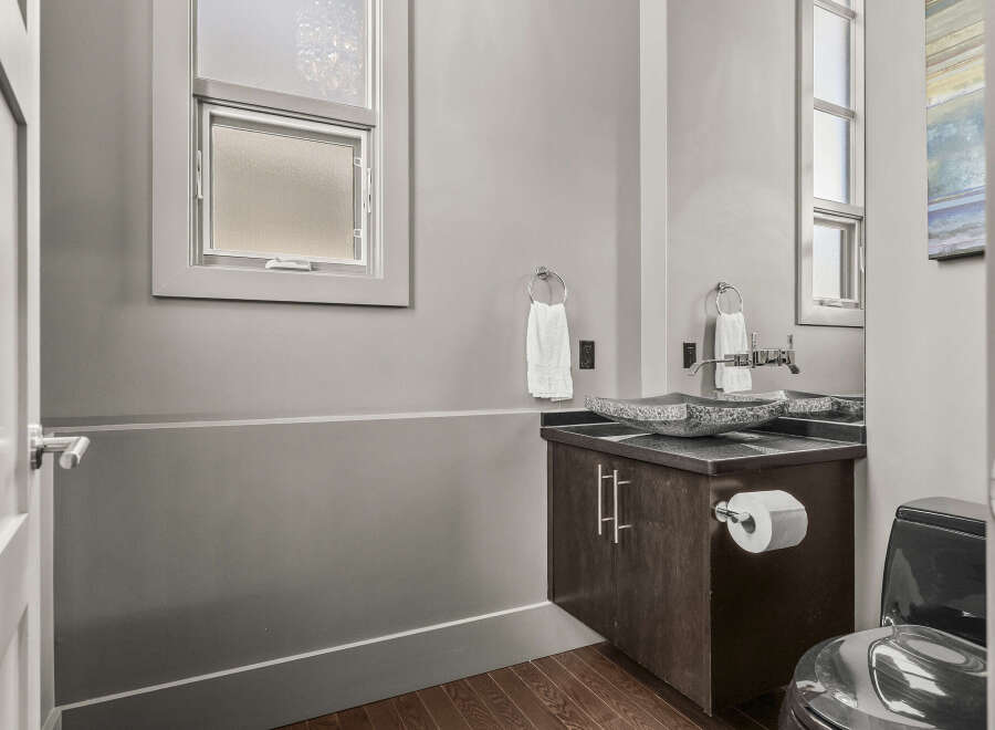 Step into this modern bathroom, featuring a stylish vanity with a unique stone sink.