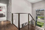This stunning property boasts a modern interior with a sleek staircase featuring glass panels and dark wood accents.