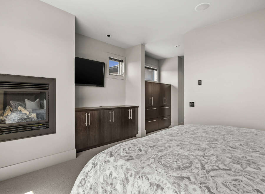 This stunning bedroom boasts a modern design with a cozy fireplace, perfect for relaxing evenings.
