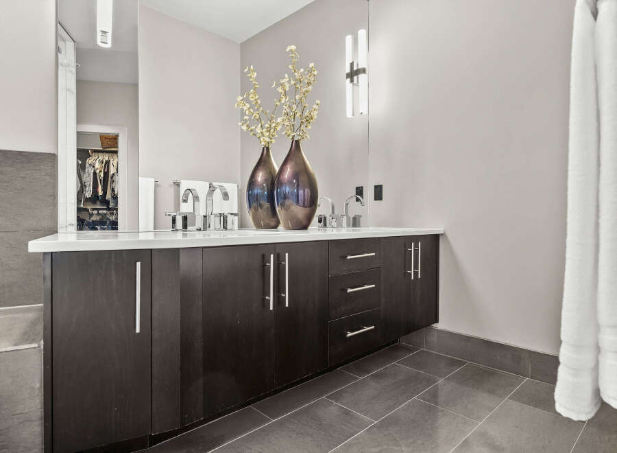 This modern bathroom features a sleek vanity with ample storage and a pristine white countertop.