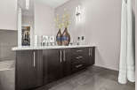 This modern bathroom features a sleek vanity with ample storage and a pristine white countertop.