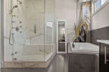 Step into luxury with this stunning bathroom featuring a spacious walk-in shower with multiple shower heads and a relaxing soaking tub.