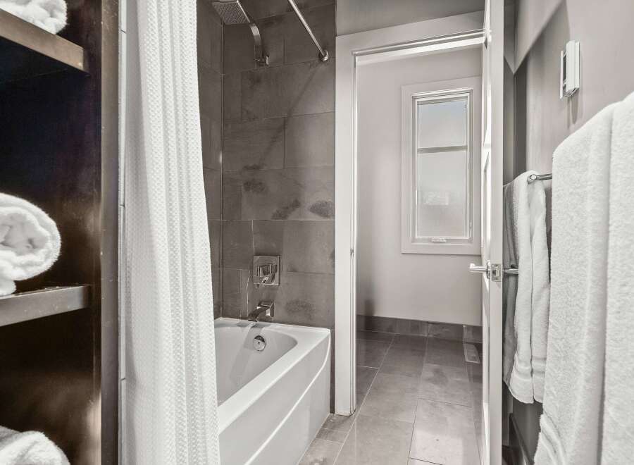 Step into a modern bathroom oasis! This space features a sleek bathtub, perfect for unwinding after a long day.