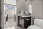 This modern bathroom features a sleek vanity with a dark wood finish, complemented by a pristine white countertop.