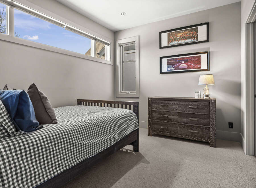 This inviting bedroom features a stylish bed with a checkered pattern, creating a cozy atmosphere.