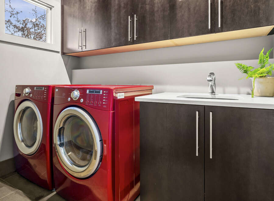 This modern laundry room features a sleek design with red LG washer and dryer units.