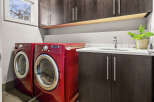 This modern laundry room features a sleek design with red LG washer and dryer units.