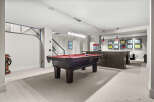 This stunning basement recreation room features a pool table, perfect for entertaining guests.