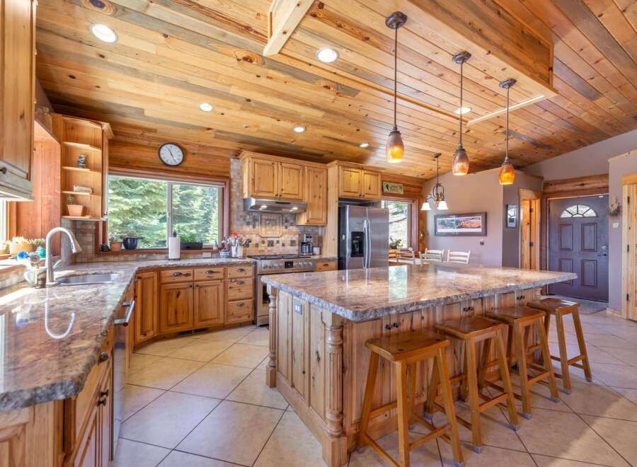 This stunning kitchen boasts a rustic charm with its wooden cabinetry, countertops, and ceiling, creating a warm and inviting atmosphere.