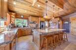 This stunning kitchen boasts a rustic charm with its wooden cabinetry, countertops, and ceiling, creating a warm and inviting atmosphere.