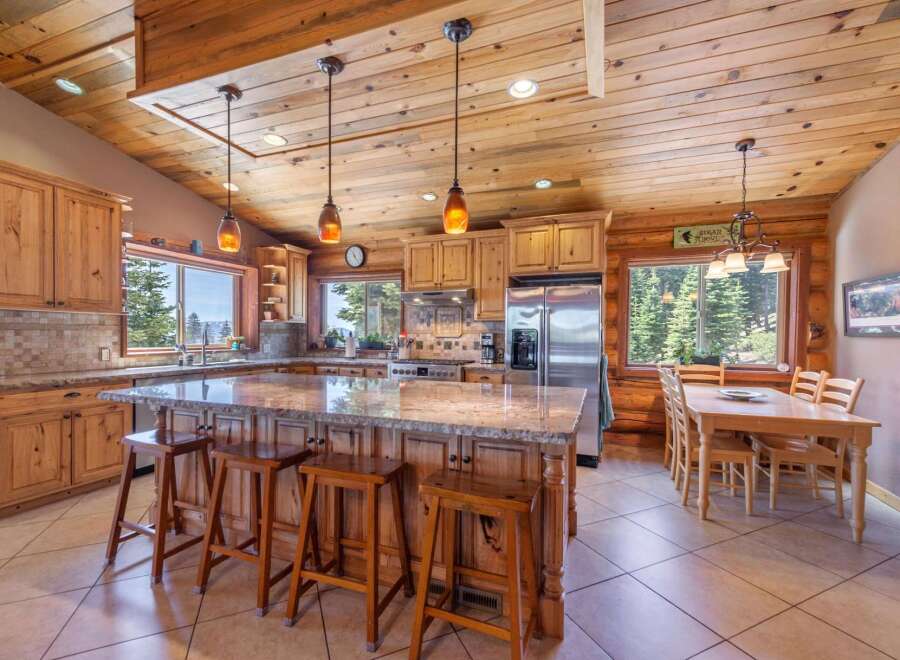 This stunning kitchen boasts a rustic charm with its wooden cabinetry, island, and ceiling.