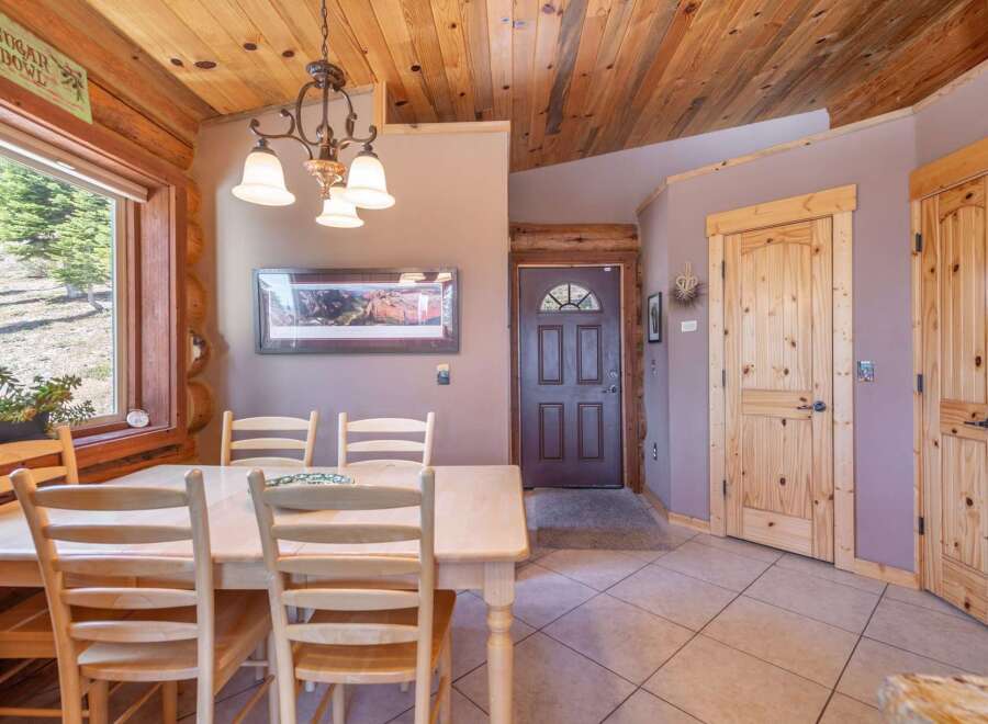 Step into this charming home featuring a cozy dining area with a wooden table and chairs, perfect for family gatherings.