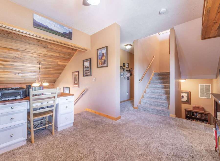 Step into this inviting home featuring a cozy workspace with a charming desk and a unique wooden accent wall.