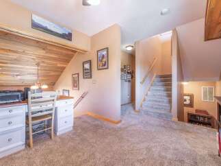 Step into this inviting home featuring a cozy workspace with a charming desk and a unique wooden accent wall.