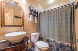Step into this charming bathroom, featuring a stylish vessel sink atop a dark vanity.