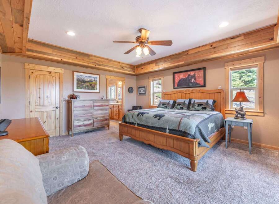 Step into this inviting bedroom, featuring a rustic wooden ceiling and a cozy ambiance.