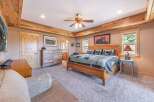 Step into this inviting bedroom, featuring a rustic wooden ceiling and a cozy ambiance.