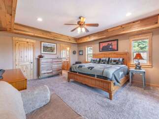 Step into this inviting bedroom, featuring a rustic wooden ceiling and a cozy ambiance.