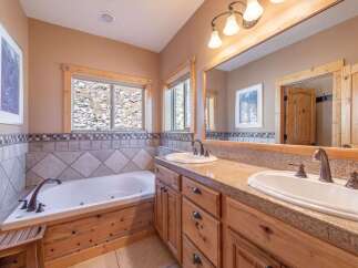 This beautiful bathroom features a luxurious soaking tub and a stylish vanity with dual sinks.