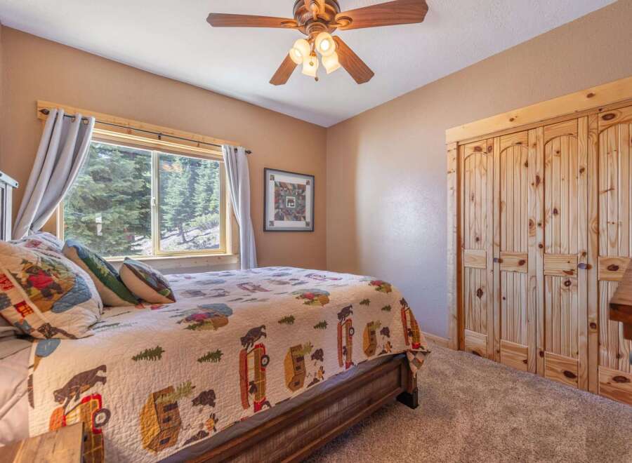 This cozy bedroom features a rustic wooden bed frame and a charming quilt, creating a warm and inviting atmosphere.
