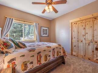 This cozy bedroom features a rustic wooden bed frame and a charming quilt, creating a warm and inviting atmosphere.
