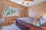 This cozy bedroom features a comfortable bed with a colorful quilt, perfect for a relaxing retreat.