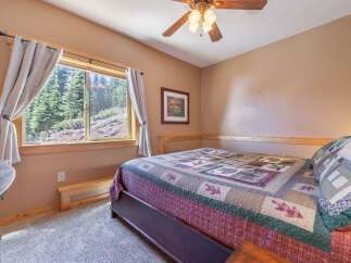 This cozy bedroom features a comfortable bed with a colorful quilt, perfect for a relaxing retreat.