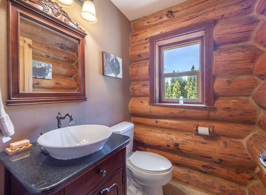 Step into rustic elegance with this charming bathroom featuring a log cabin aesthetic.