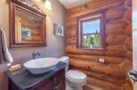 Step into rustic elegance with this charming bathroom featuring a log cabin aesthetic.