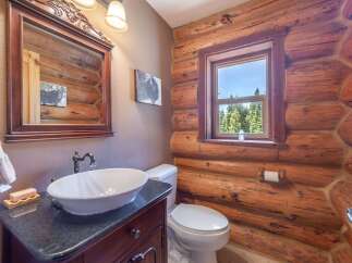Step into rustic elegance with this charming bathroom featuring a log cabin aesthetic.
