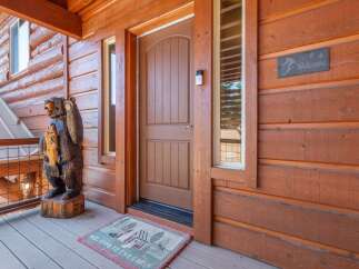 Welcome to your mountain retreat! This charming cabin boasts a warm and inviting entrance, perfect for greeting guests.