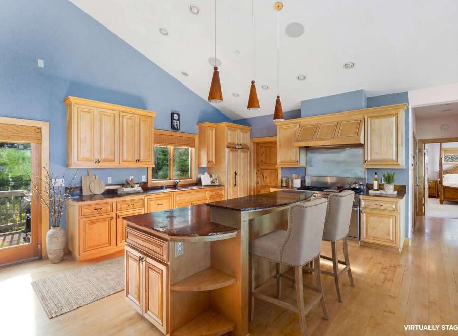 This stunning kitchen boasts a spacious layout with beautiful wooden cabinetry and a large island, perfect for both cooking and entertaining.
