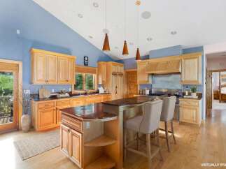 This stunning kitchen boasts a spacious layout with beautiful wooden cabinetry and a large island, perfect for both cooking and entertaining.