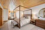 Step into luxury with this stunning bedroom featuring a beautiful wooden ceiling and a grand four-poster bed.